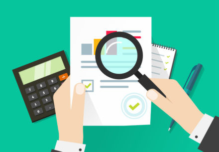 Hands examining a financial document with a magnifying glass, symbolizing the detailed process of invoice reconciliation for accuracy.