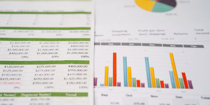 Close-up of financial spreadsheets with numerical data and colorful bar charts, illustrating financial data spreading and analysis.